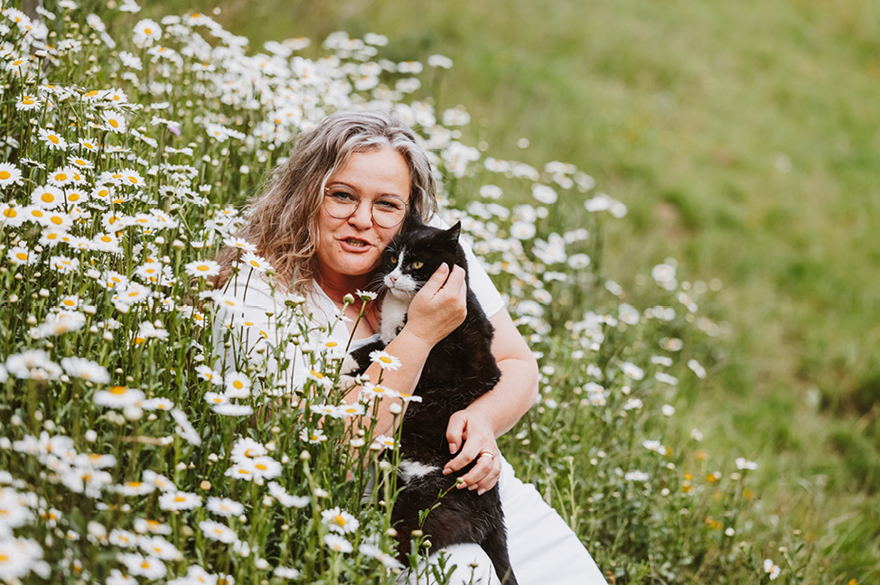 Maria mit Katze auf einer Blumenwiese