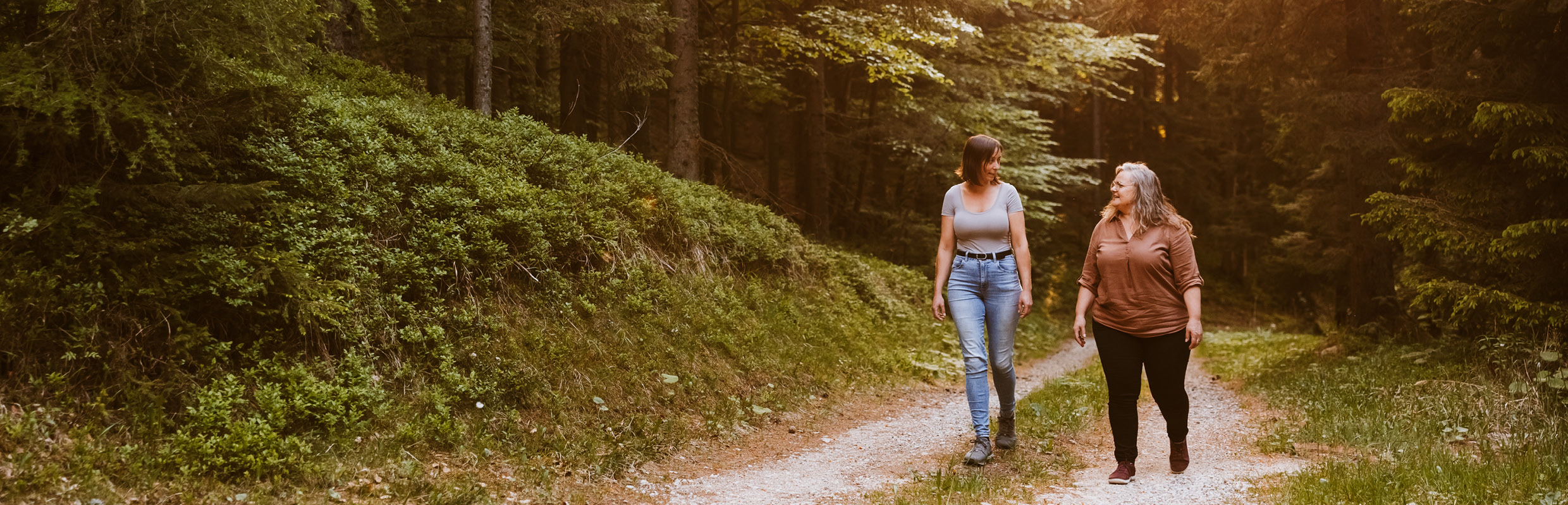 Maria im Naturgespräch mit Kundin im Wald gehend